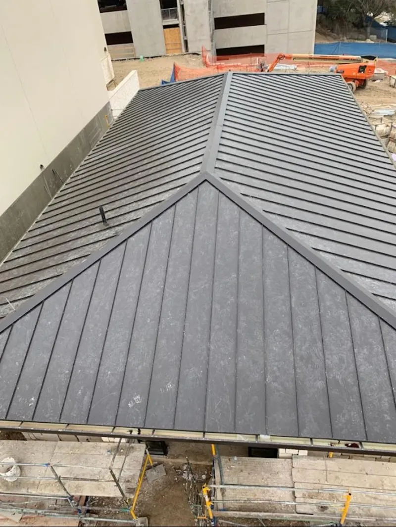 Commercial metal roof construction with crane equipment in Orchard Homes